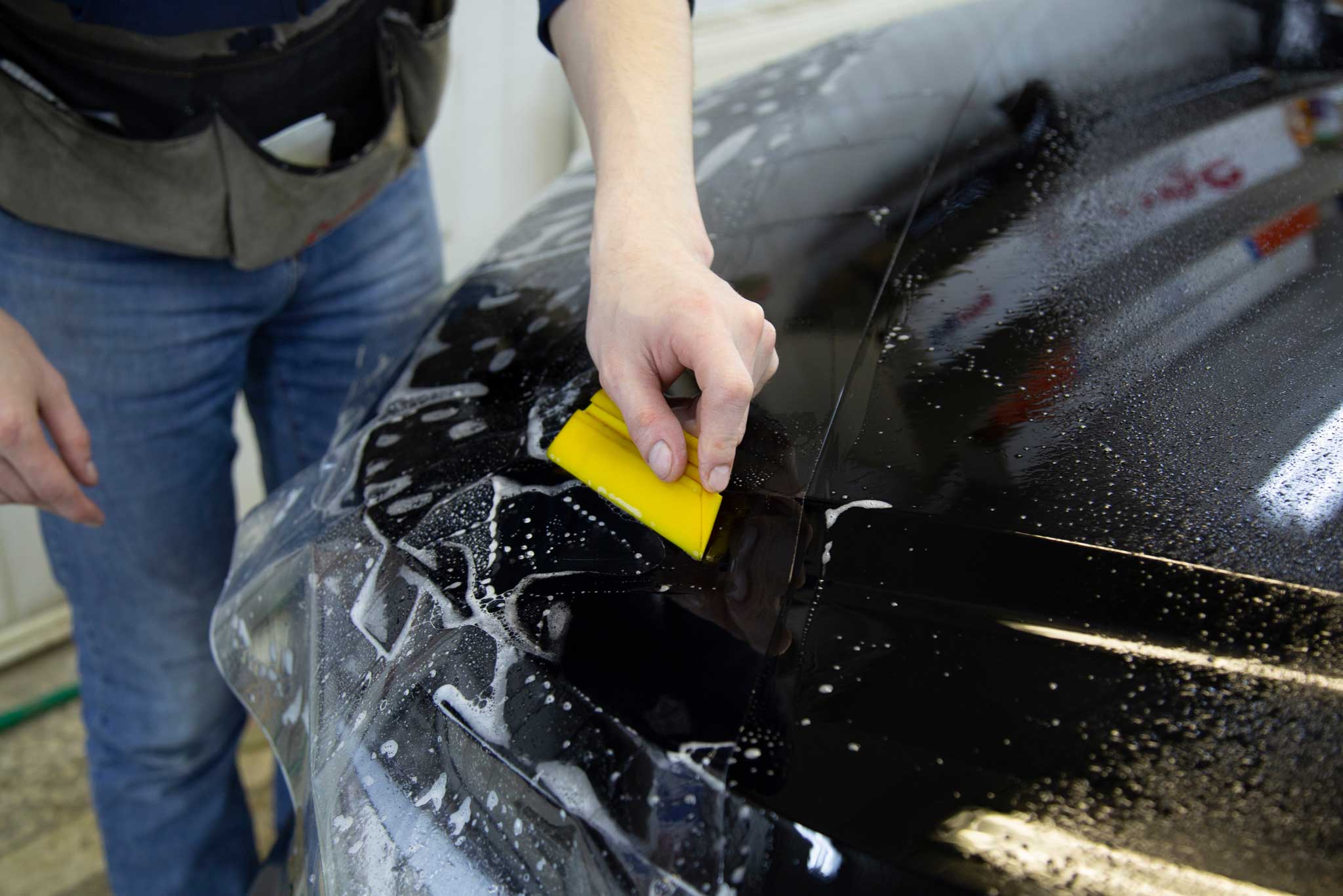 application of paint Protection film on black car hood